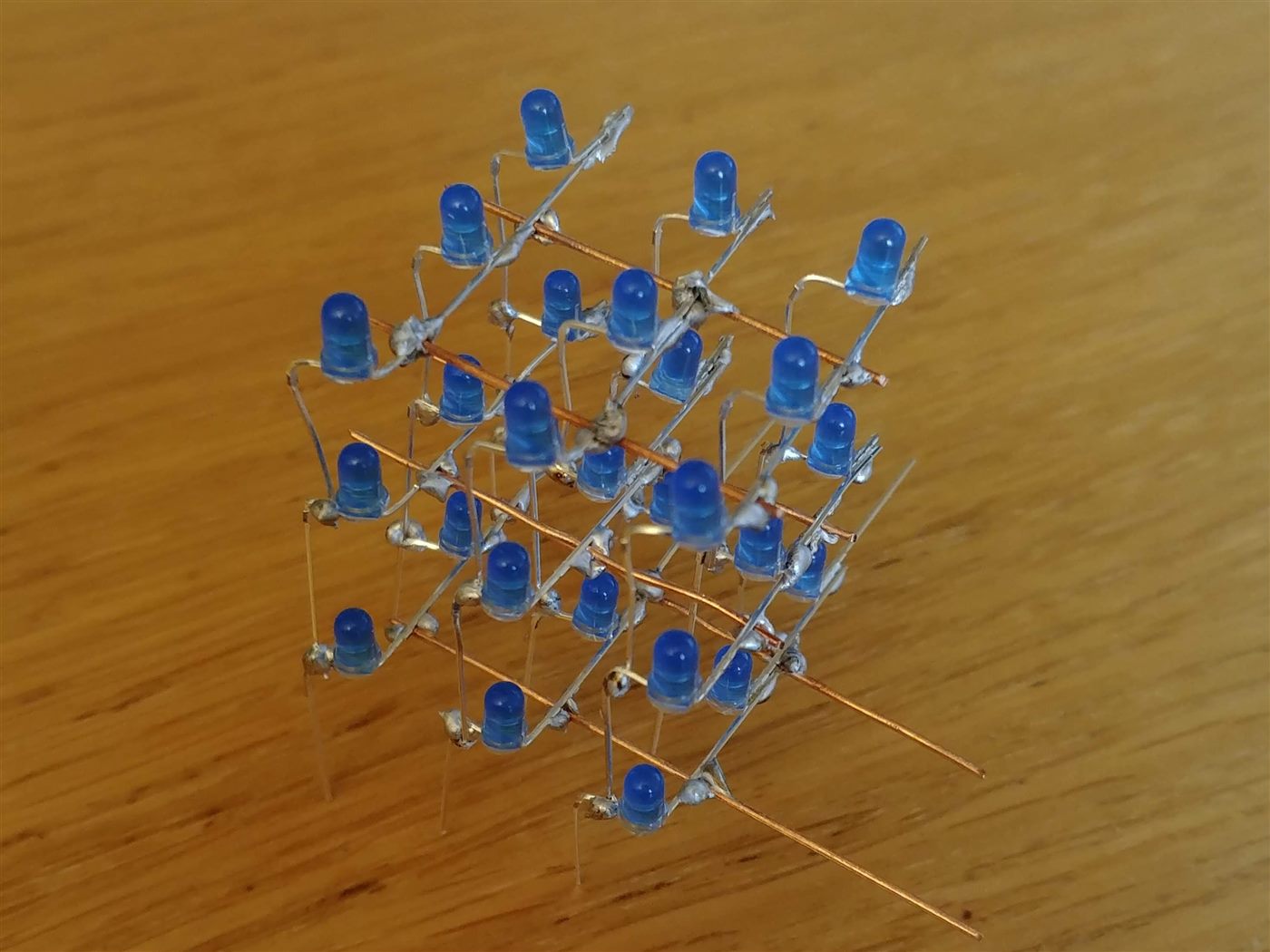 Hand-soldered three-dimensional cube of blue LEDs