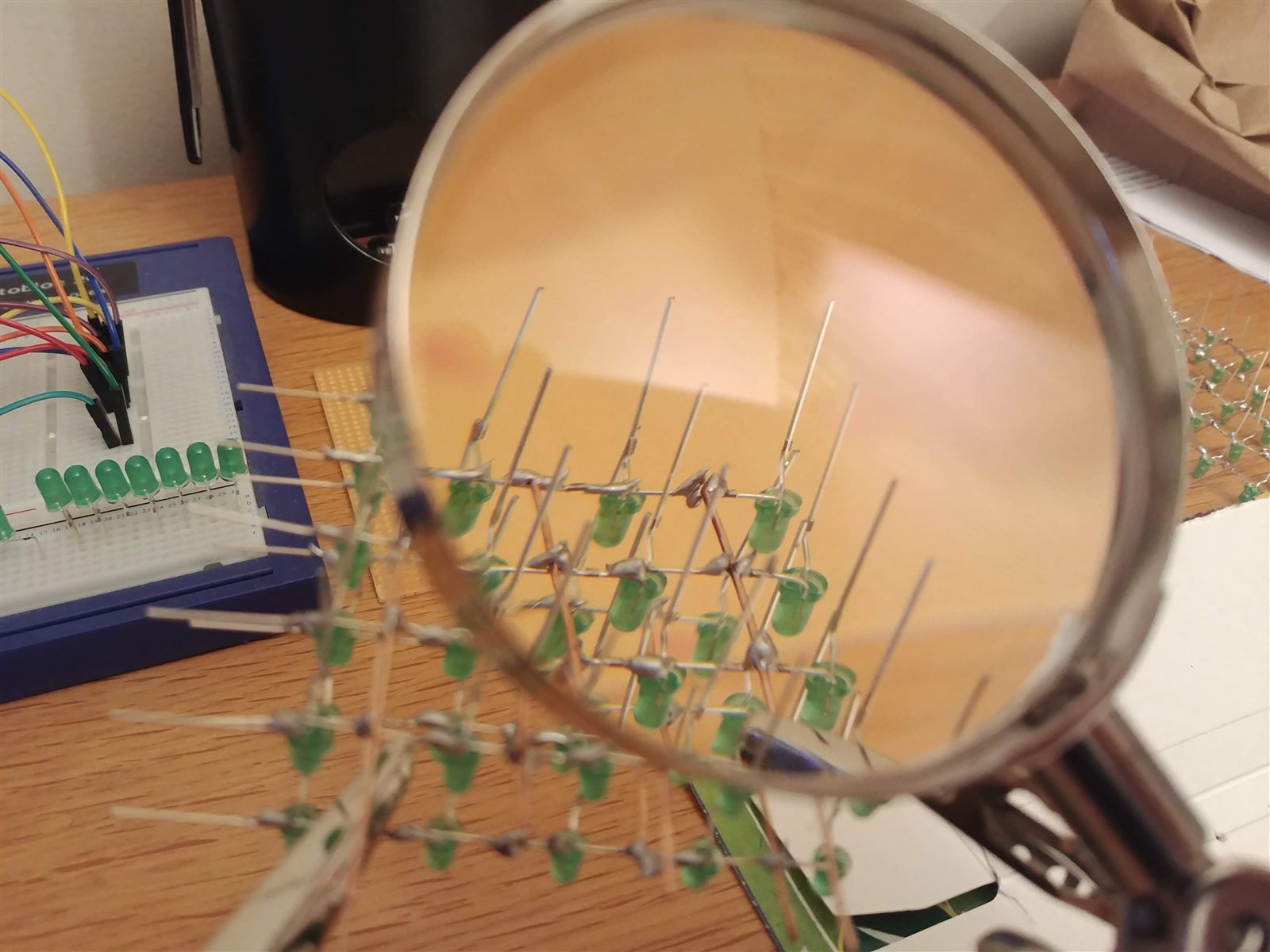 Green LED matrix being inspected through a magnifying glass