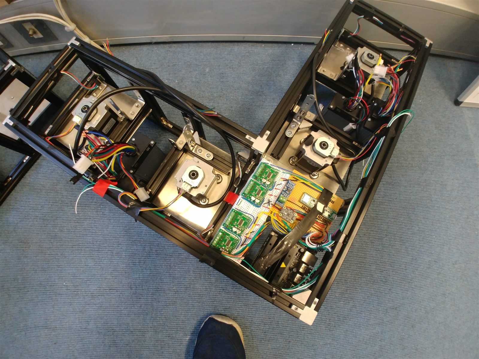 Three autonomous robot prototypes with exposed electronics and black aluminium frames